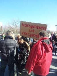 Einige Protestierende mit Plakat: Versprochen ist versprochen