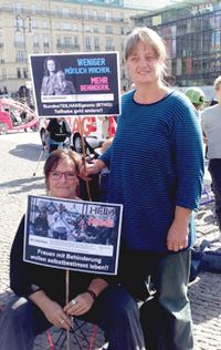 Brigitte Faber und Martina Puschke vom Weibernetz halten Plakate hoch