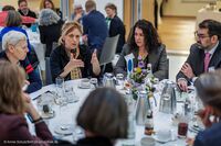 Foto: Bundesministerin Karin Prien im lebhaften Gespräch am runden Kaffeetisch mit aufmerksam zuhörenden Gästen.