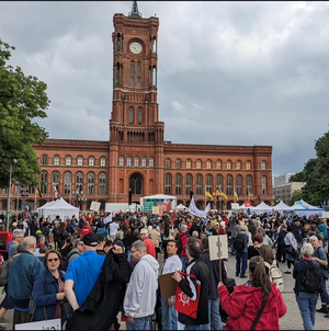 Foto: eine große Menschenmenge mit Transparenten vor dem Roten Rathaus in Berlin.