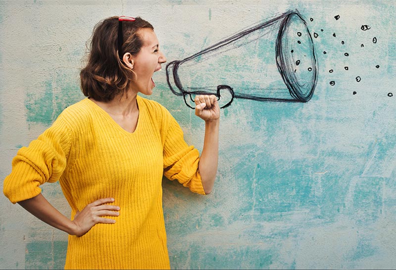 Frau vor einer Wand ruft etwas in ein stilisiertes Megaphon